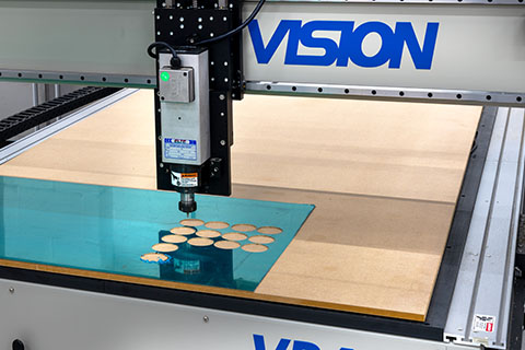 Laser cutter machine cutting circular shapes from thin material